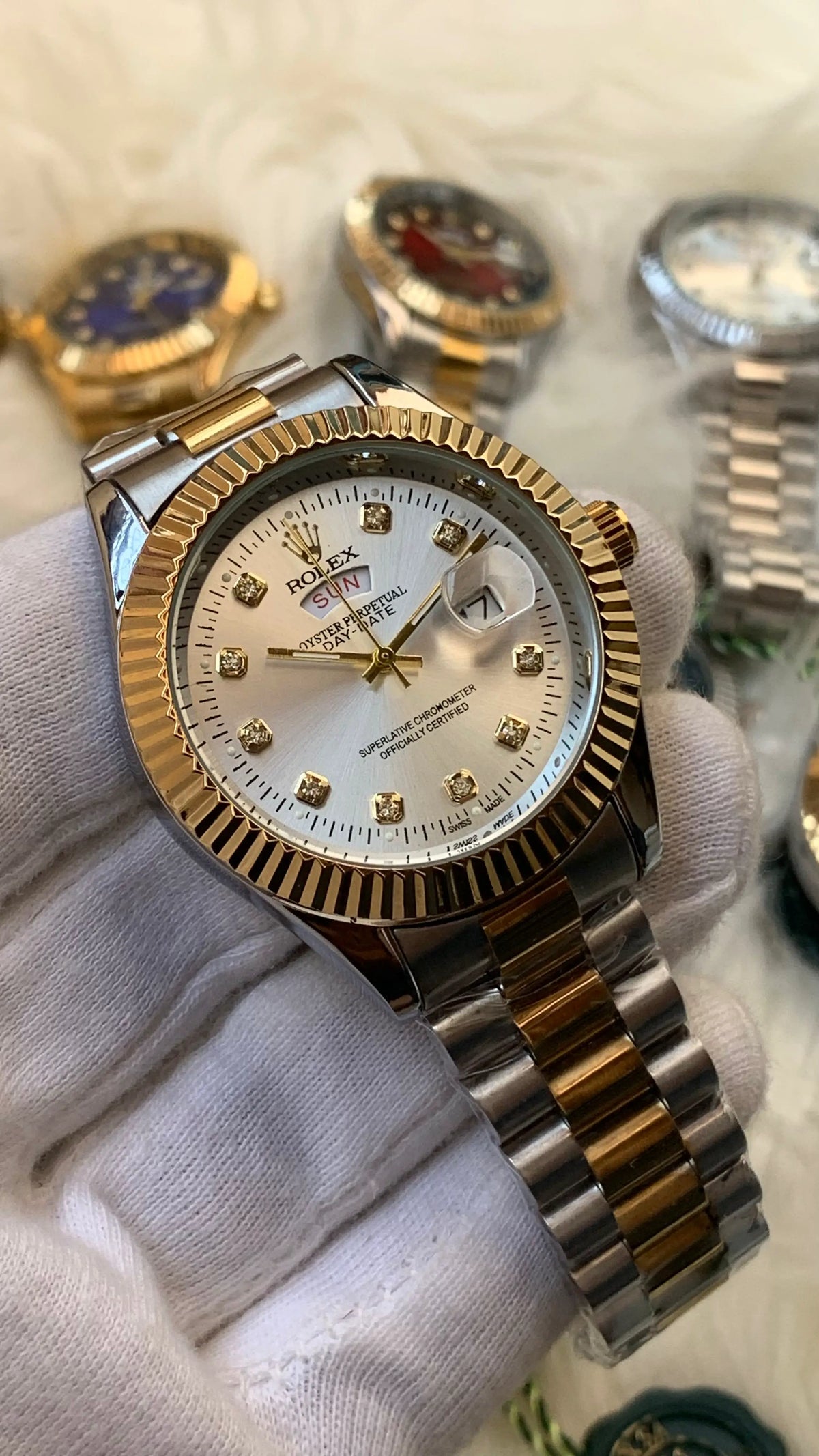 Gold and silver watch with diamond-studded face on a white cloth