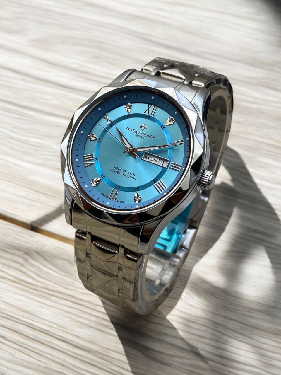 Silver watch with a blue face on a textured surface