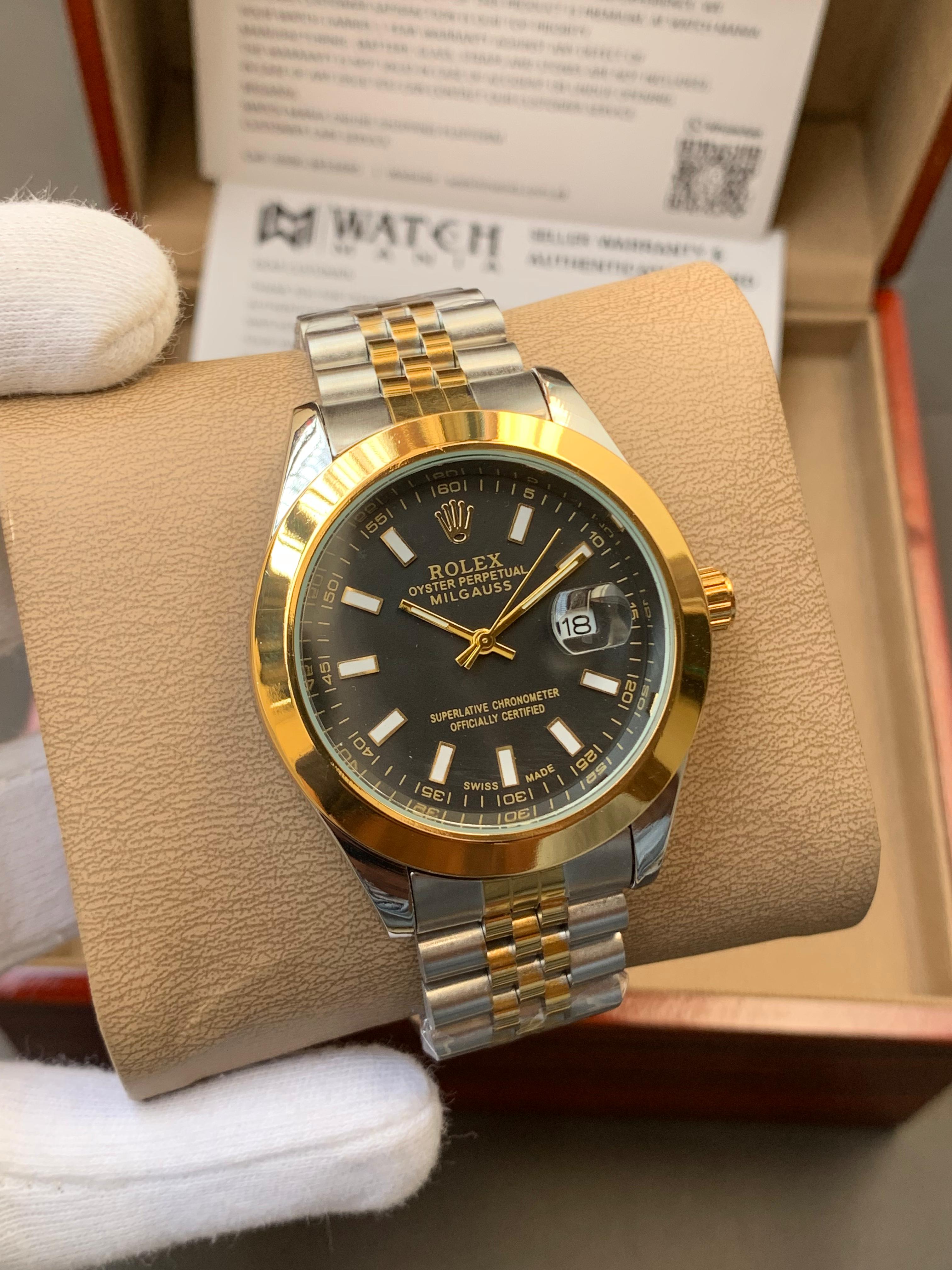 Gold and silver watch with black dial on a brown cushion, brand name visible