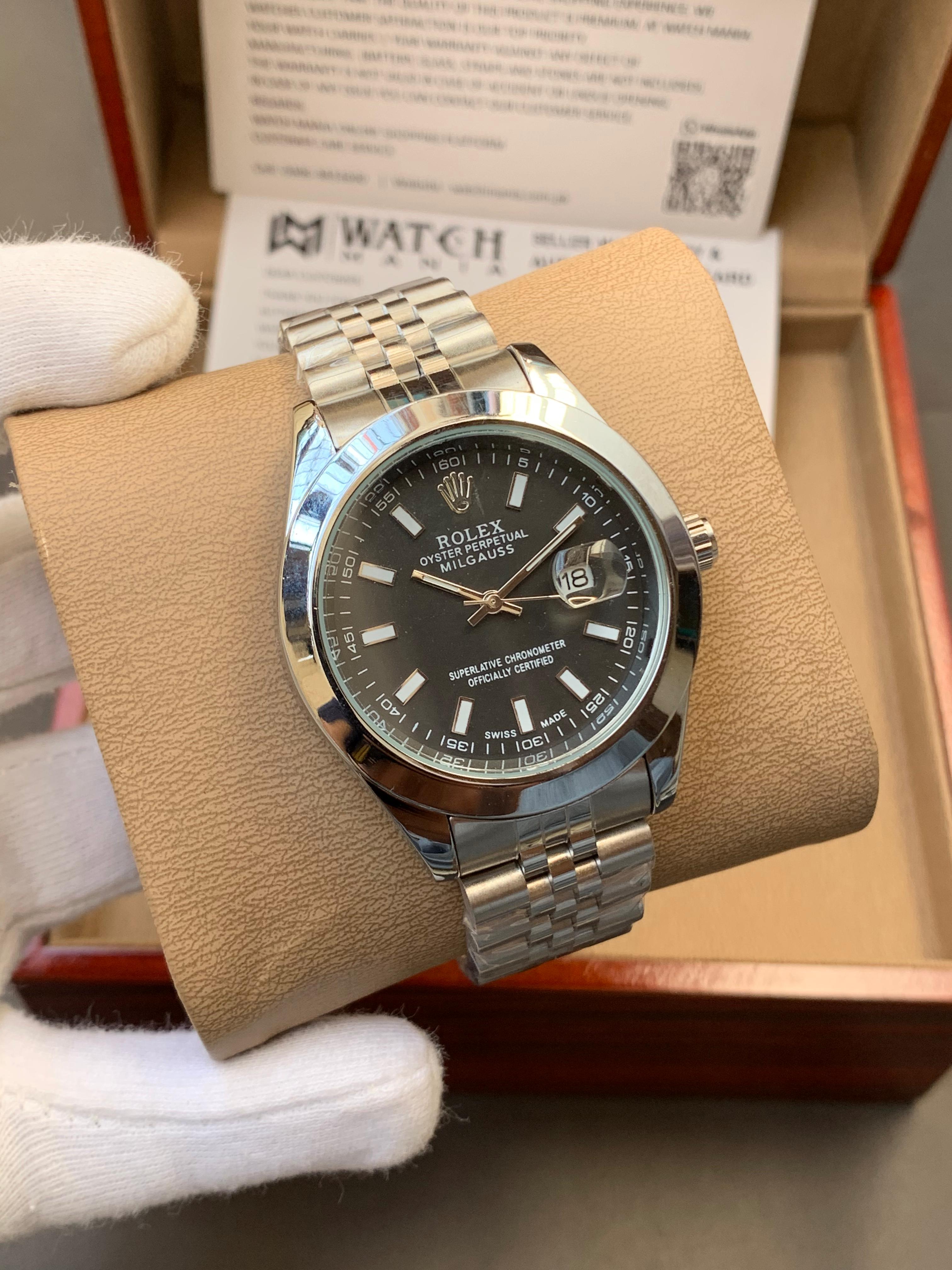 Silver watch with black dial on a brown cushion in a box