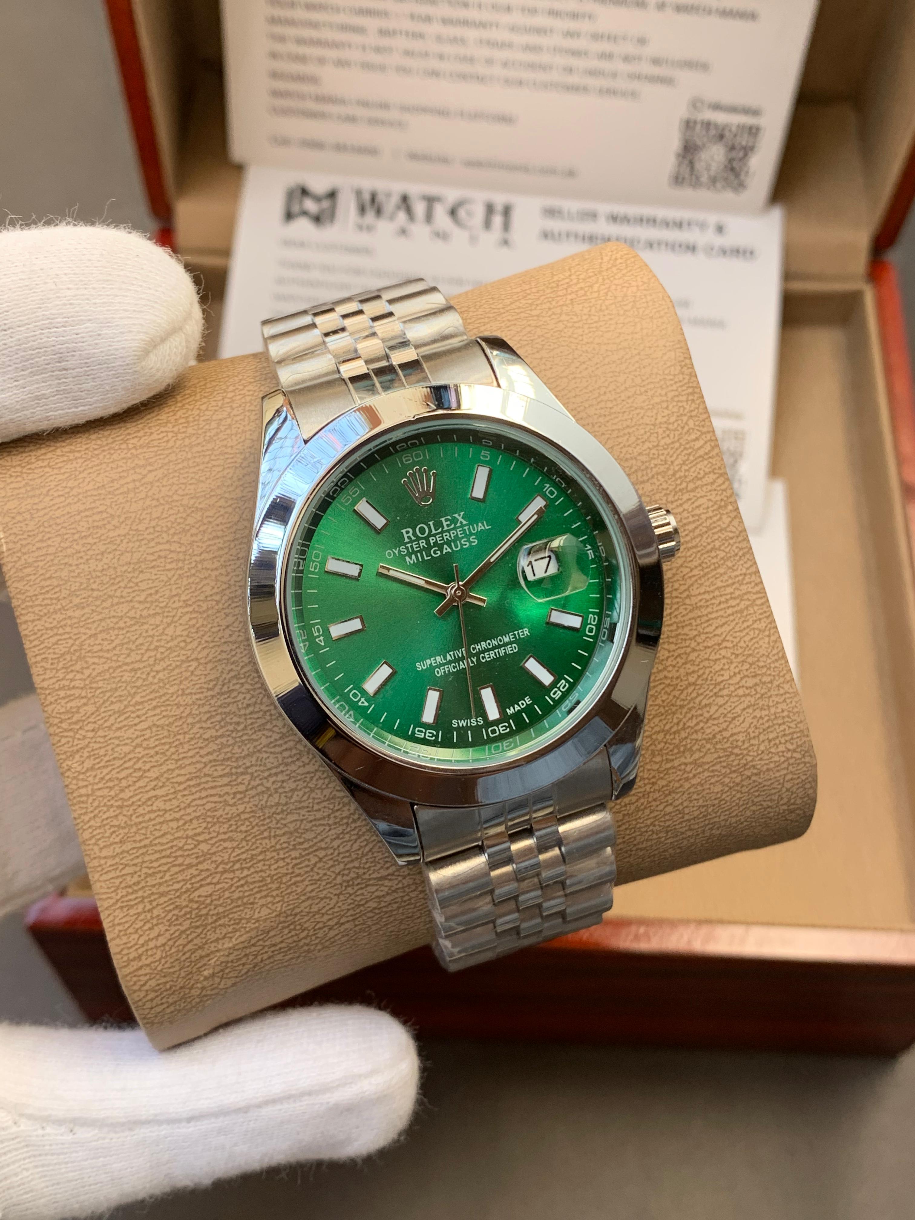 Rolex watch with green dial and silver metal bracelet on a brown cushion