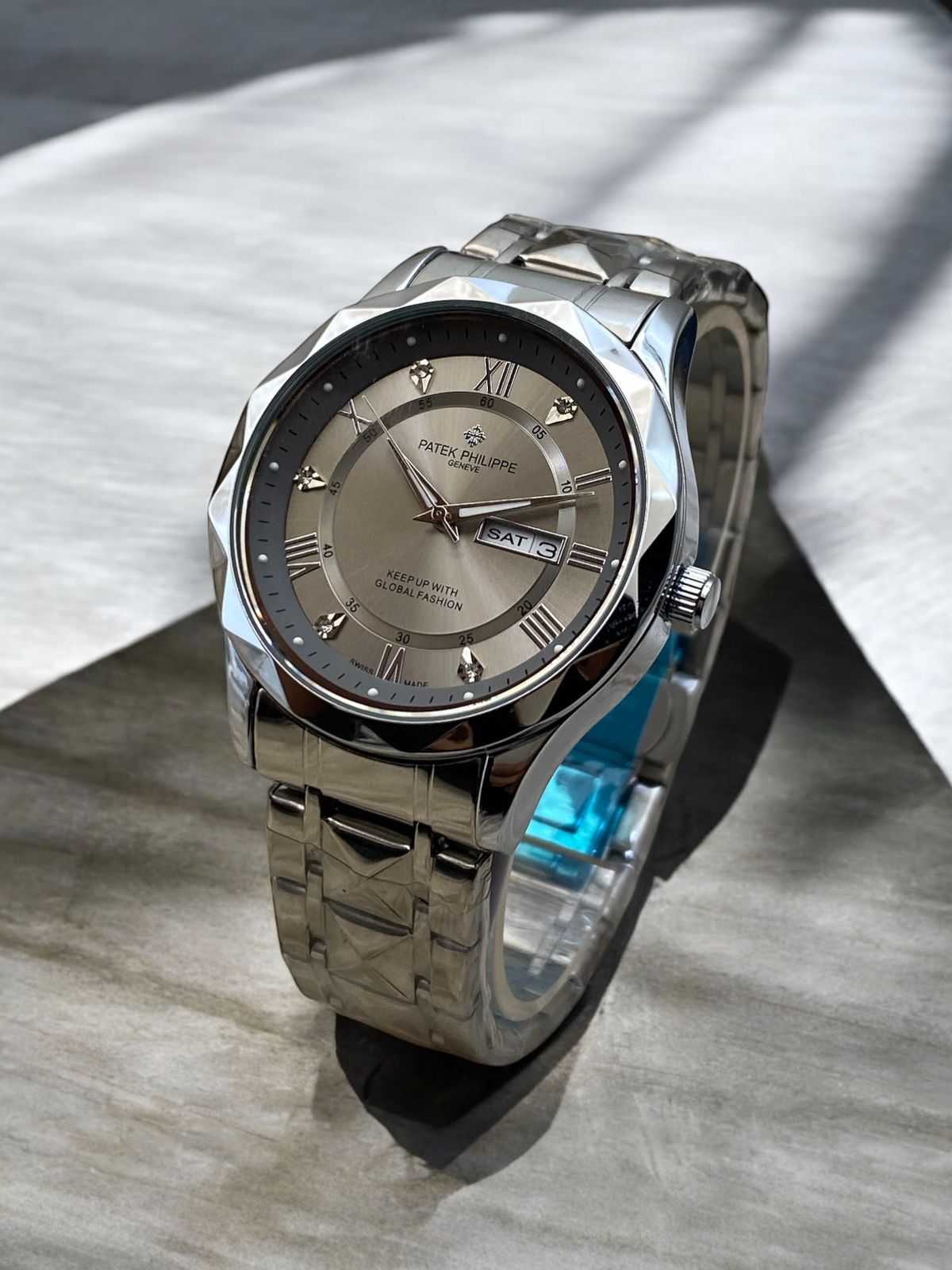 Silver wristwatch with a metallic band on a light wooden surface