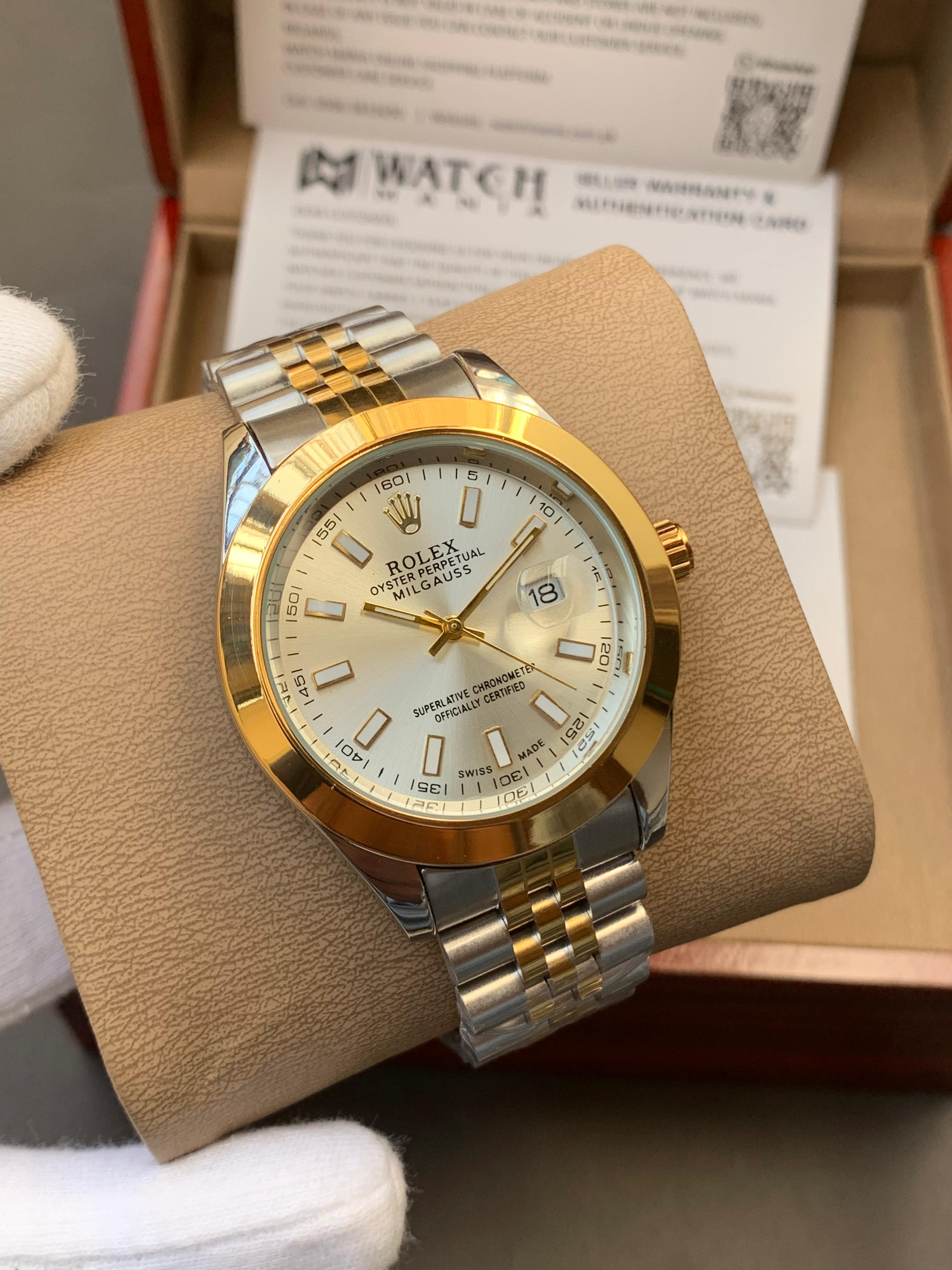 Gold and silver watch on a brown cushion with a blurred background